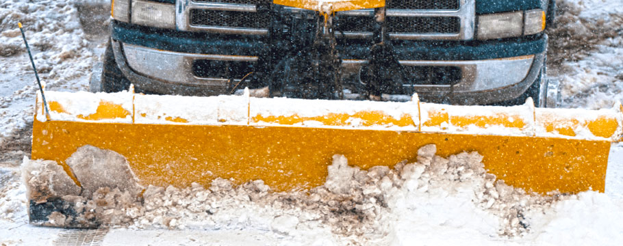 truck pushing yellow snow plough arlington massachusetts snow and ice removal relocation and shoveling for commercial and residential